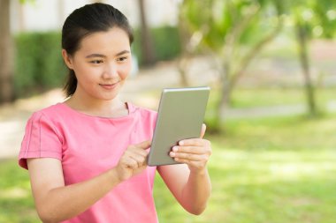 Kadın bahçede tablet kullanmak