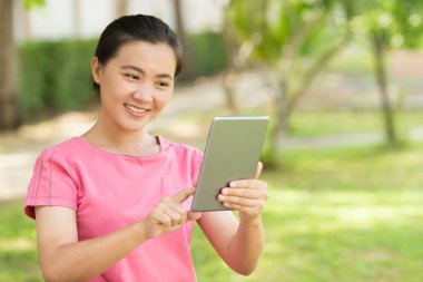 Kadın bahçede tablet kullanmak