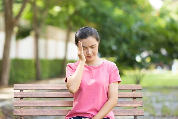 Mujer tiene dolor de cabeza en el jardín — Foto de Stock