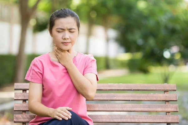 Mujer tiene dolor de garganta en el jardín — Foto de Stock