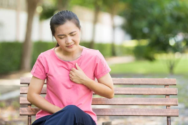 Mujer tiene dolor en el pecho en el jardín — Foto de Stock