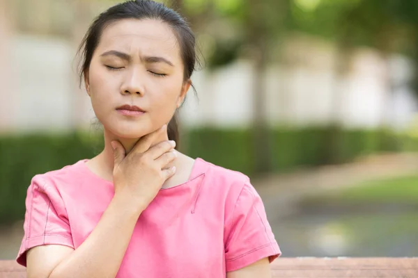 Mujer tiene dolor de garganta en el jardín — Foto de Stock