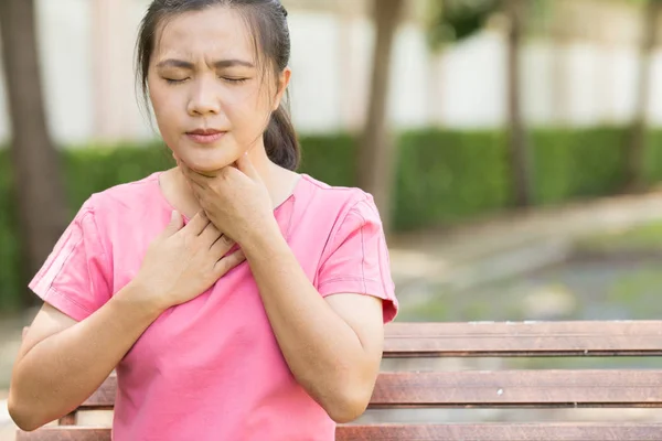 Mujer tiene dolor de garganta en el jardín — Foto de Stock