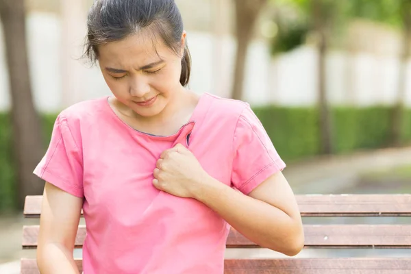 Woman has chest pain in the garden — Stock Photo, Image