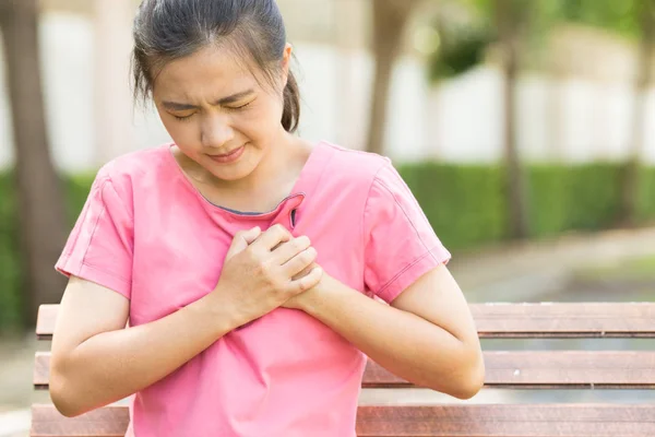 Woman has chest pain in the garden — Stock Photo, Image