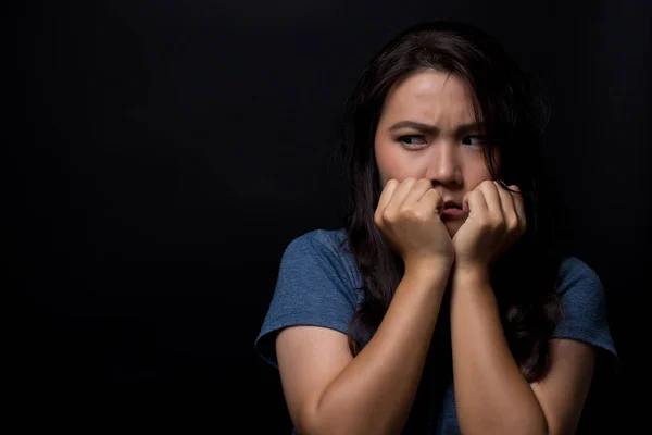 Mujer asustada sobre fondo negro aislado — Foto de Stock