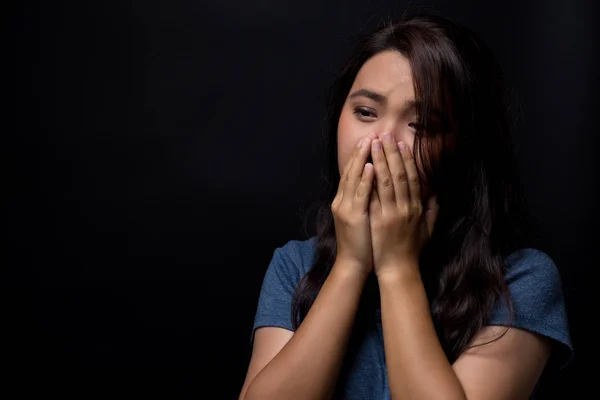 Sad woman on isolated black background