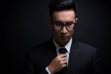 Adam siyah takım elbise ve kravat onun ayarlama