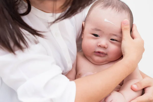 Madre aplicando loción para bebé para hijo —  Fotos de Stock