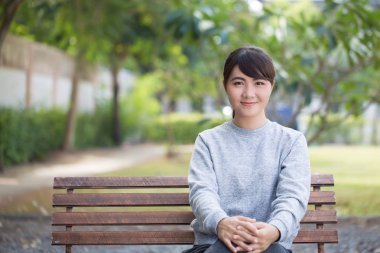 Mutlu kadın parkta bankta oturmuş