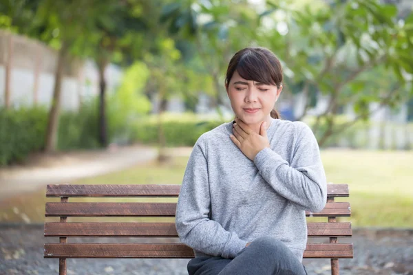 Mujer tiene dolor de garganta en el parque — Foto de Stock