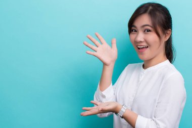 Asyalı kadın mavi arkaplanda izole edilmiş kopya alanını göster