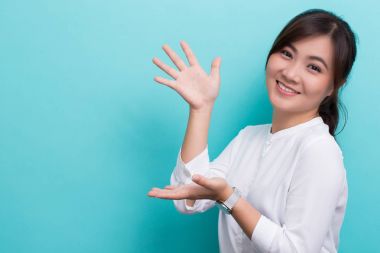 Asyalı kadın mavi arkaplanda izole edilmiş kopya alanını göster