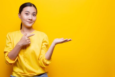 Sarı arkaplan üzerinde izole edilmiş kopyalama alanını gösteren kadın