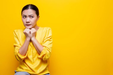 Kadın, sarı arka planda yalnız kalmaktan korkuyor.