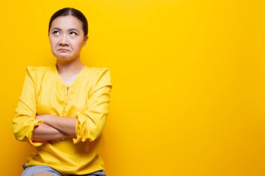 Kadın, sarı arka planda izole edilmiş iğrenme hareketi göster