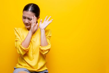 Kadın, sarı arka planda yalnız kalmaktan korkuyor.