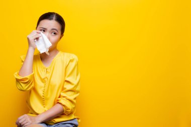 Üzgün kadın ağlıyor ve gözyaşlarını kağıt mendille siliyor.