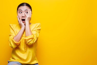 Kadın, sarı arka planda yalnız kalmaktan korkuyor.