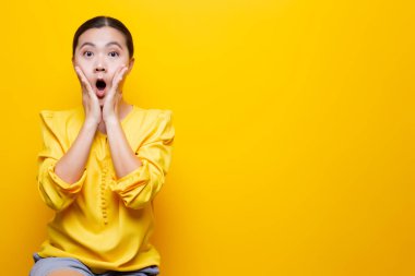 Kadın, sarı arka planda yalnız kalmaktan korkuyor.