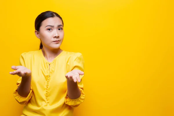 Mujer sentirse confundido aislado sobre fondo amarillo — Foto de Stock