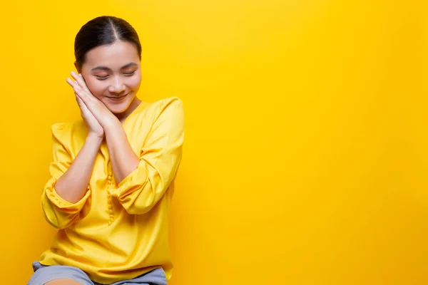 Kvinna känner sig blyg stående isolerad över gul bakgrund — Stockfoto