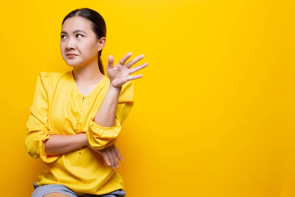 Mulher mostra gesto de nojo isolado sobre fundo amarelo — Fotografia de Stock