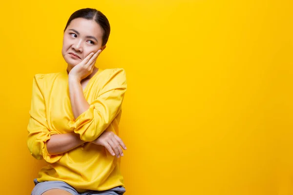 Woman show disgust gesture isolated over yellow background — Stock Photo, Image