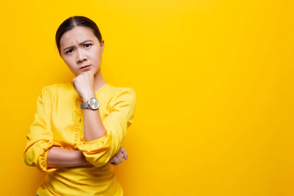 Kobieta czuje się zdezorientowana na żółtym tle — Zdjęcie stockowe