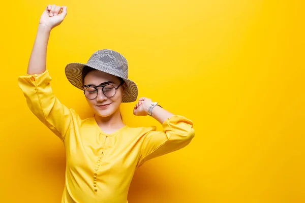 黄色のb上に隔離されたサングラスと帽子を身に着けている肖像女性 — ストック写真