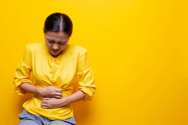 Mujer tiene dolor de estómago aislado sobre fondo amarillo — Foto de Stock