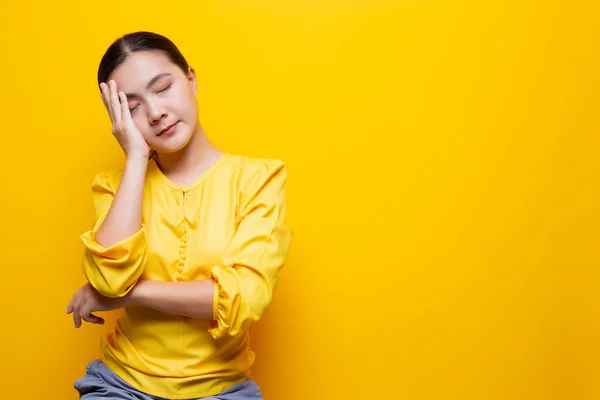 Mulher tem dor de cabeça isolada sobre fundo amarelo — Fotografia de Stock