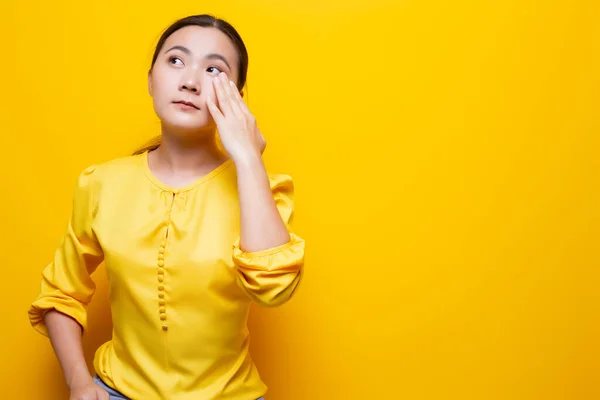 Mujer tiene los ojos dolor aislado sobre fondo amarillo —  Fotos de Stock