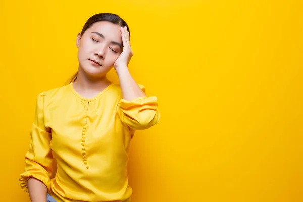 Mujer tiene dolor de cabeza aislado sobre fondo amarillo —  Fotos de Stock