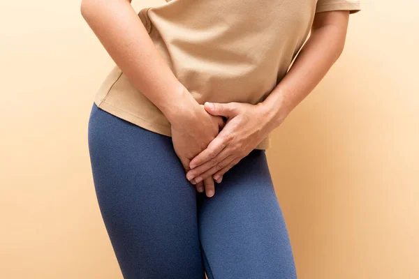 Closeup sick woman with hands holding pressing her crotch isolat — Stock Photo, Image