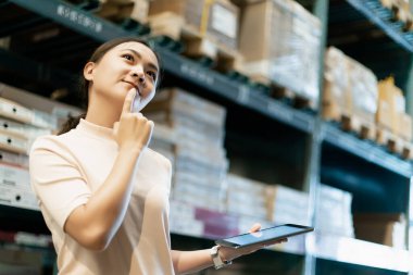 Mobilya alışverişi yapan ve tabletini kullanan bir kadın.