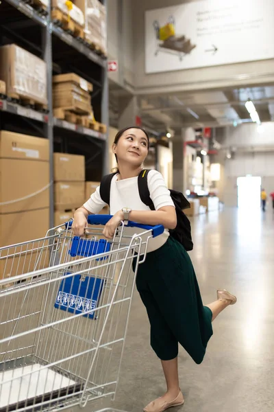 Vrouw gebruik winkelwagentje voor winkelmeubelen in magazijn — Stockfoto