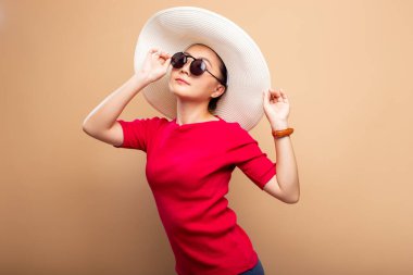 Kahverengi bej arka grubunda izole edilmiş büyük şapkalı bir portre kadın.