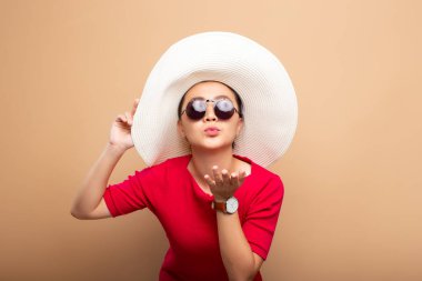 Kahverengi bej arka grubunda izole edilmiş büyük şapkalı bir portre kadın.
