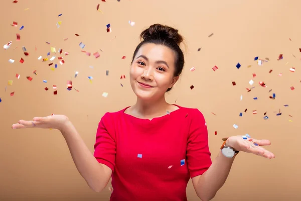 Retrato de una mujer alegre con lluvia de confeti y celebrando —  Fotos de Stock