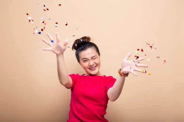 Retrato de una mujer alegre con lluvia de confeti y celebrando —  Fotos de Stock