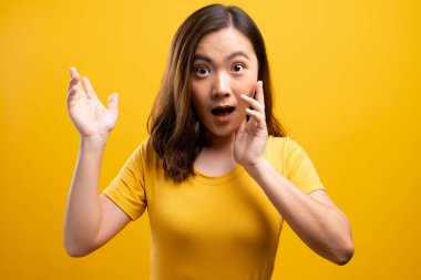 Kadın, sarı arka planda izole edilmiş dedikodu hareketi yapıyor.