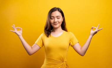 Yoga jestinde elini tutarak meditasyon yapan bir kadın.