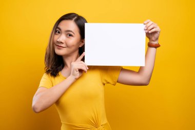 Sarı arkaplan üzerinde kağıt kopyalama alanı gösteren kadın
