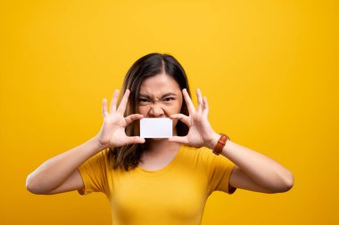 Kızgın kadın kağıt kartla yüzünü kapatıyor.