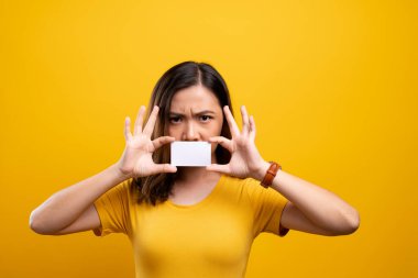 Kızgın kadın kağıt kartla yüzünü kapatıyor.