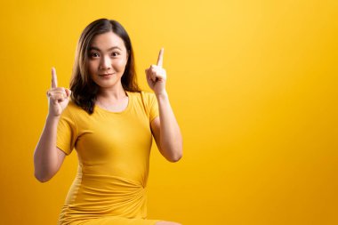 Mutlu kadın düşünüyor ve dikiliyor sarı sırtüstü