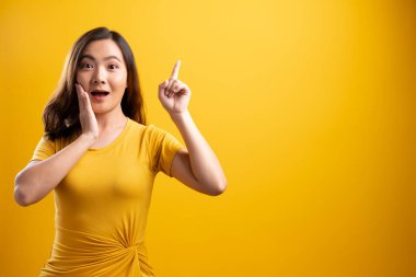 Mutlu kadın düşünüyor ve dikiliyor sarı sırtüstü