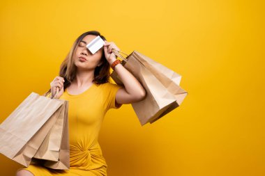 Alışveriş çantası ve kredi kartı taşıyan kadının portresi izole edilmiş.