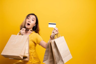 Alışveriş çantası ve kredi kartı taşıyan mutlu bir kadın. 